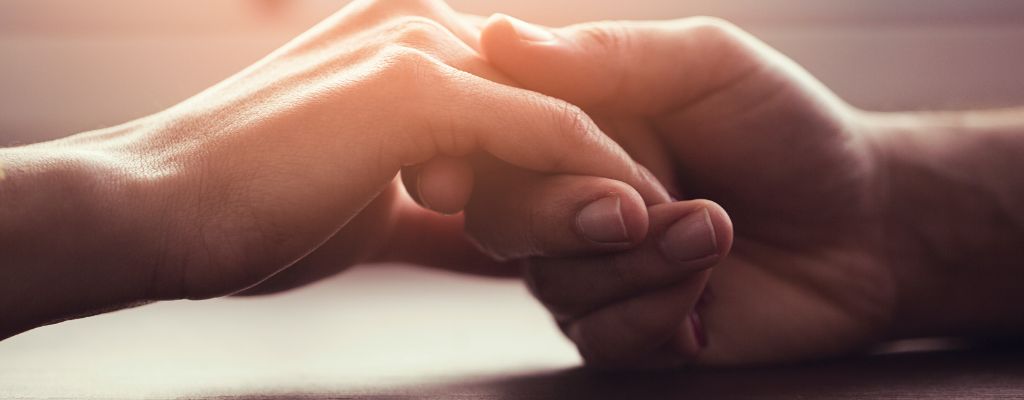 photograph of two peoples hands holding onto each other